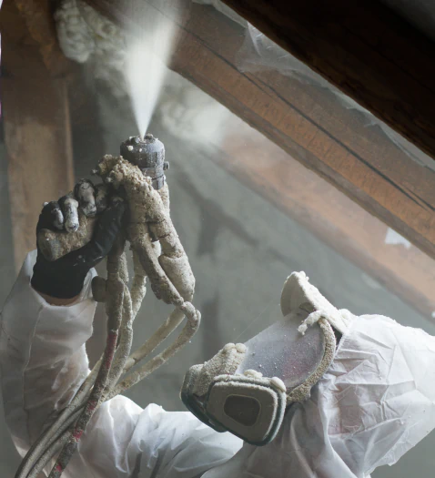 worker spraying insulation foam